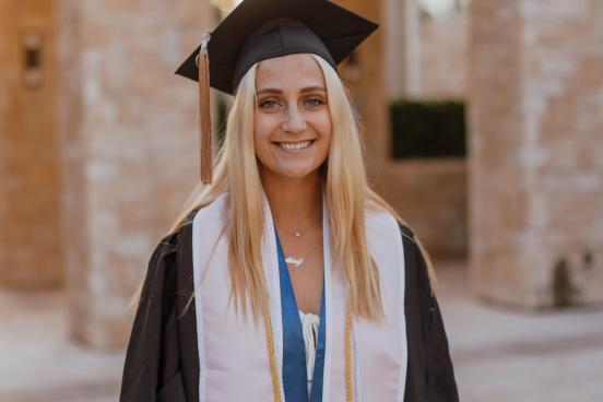 Abbey Serio, smiling and wearing her cap and gown