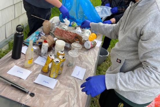 picture of students sorting through waste bags 