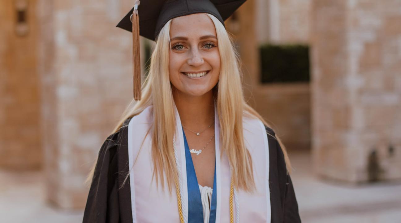 Abbey Serio, smiling and wearing her cap and gown
