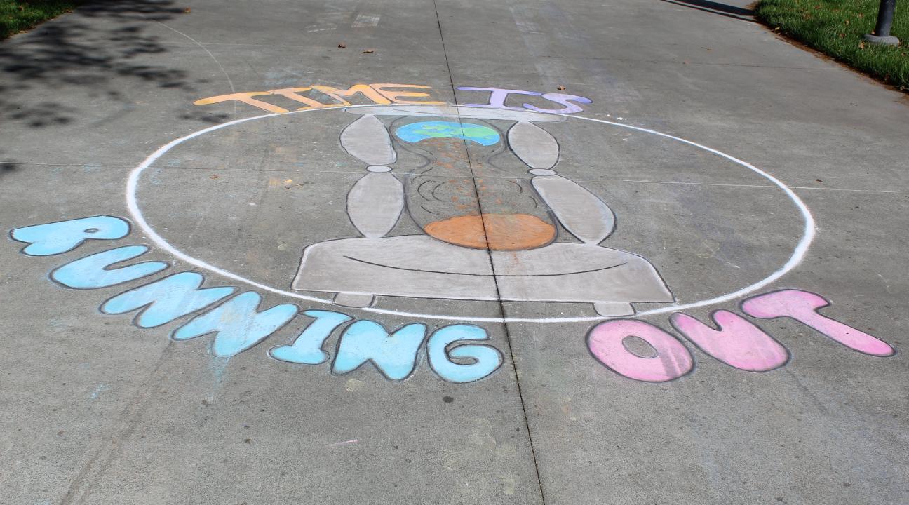 sidewalk chalk art displaying hourglass and words time is running out