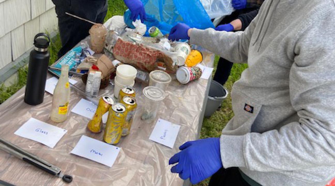 picture of students sorting through waste bags 