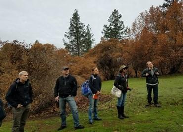 5 people before a grove of trees.