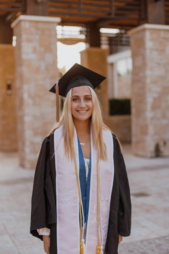 Abbey Serio, smiling and wearing her cap and gown