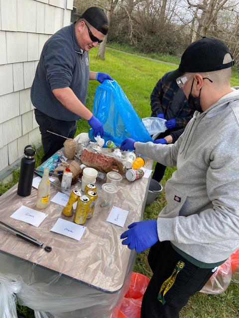 picture of students sorting through waste bags 